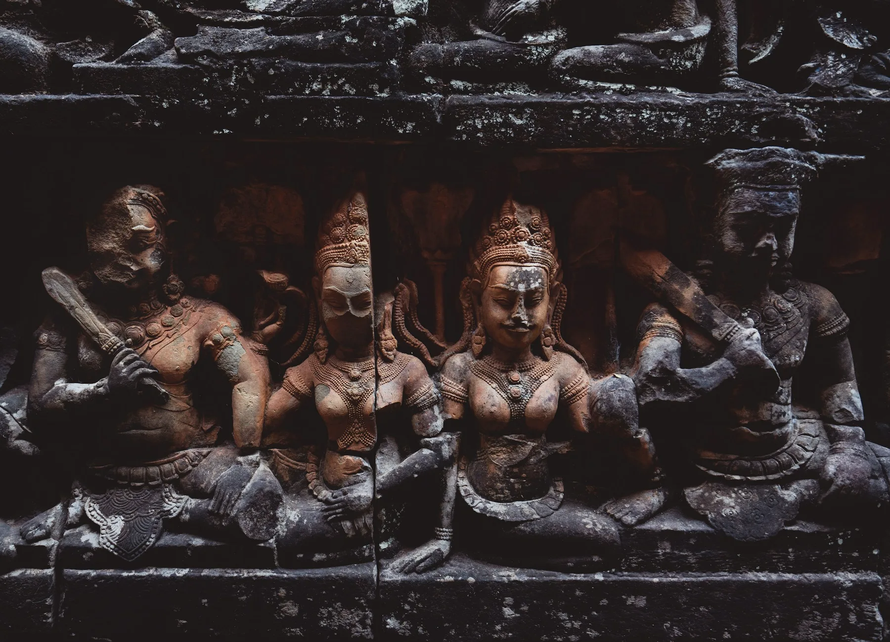 Figures carved into a stone relief at Angkor Wat
