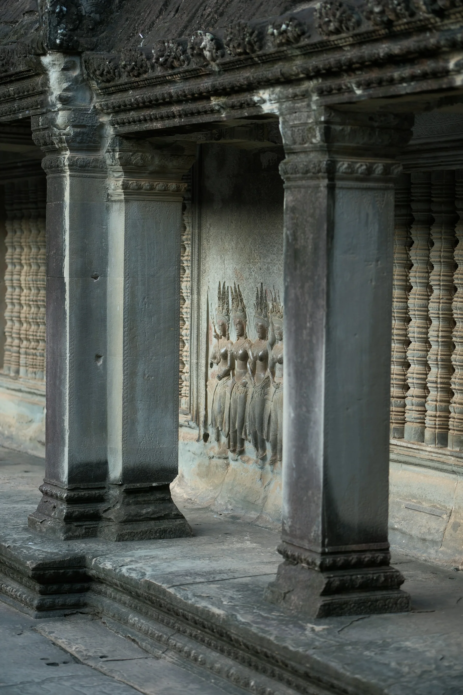 Light falling through the carved stone columns of Angkor Wat